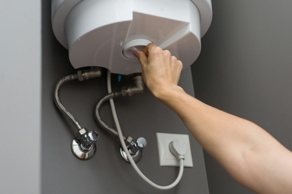 Woman hands setting temperature of water in heater electric boiler. Interior details close-up